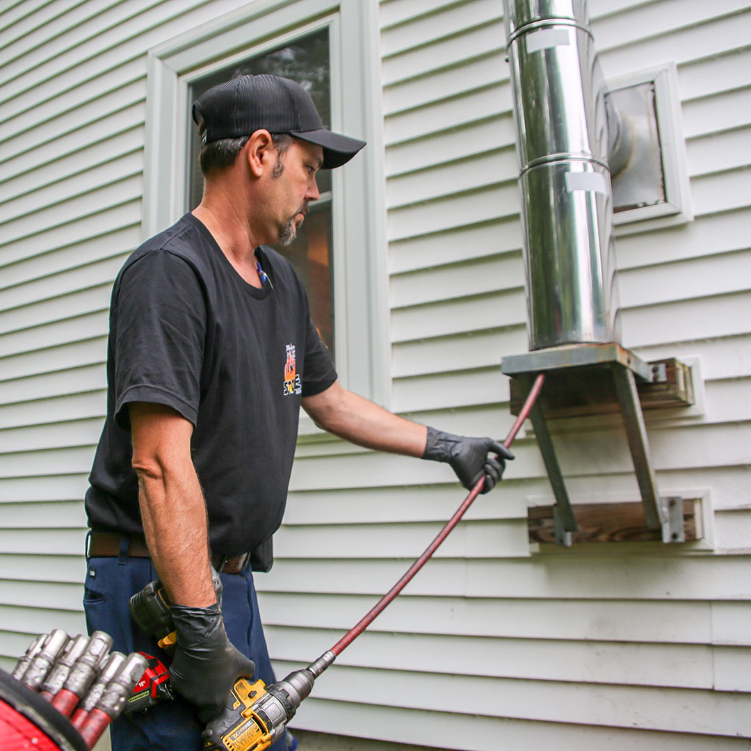 Chimney sweep cleaning chimney in Manchester, NH.